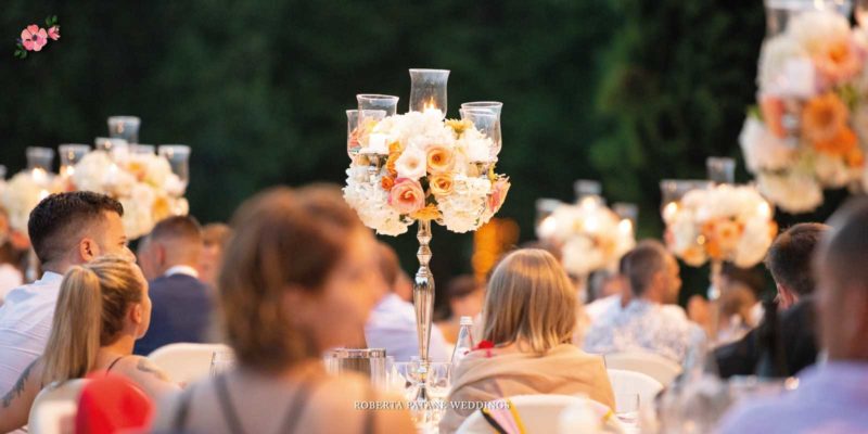 Centrotavola alto e colorato posizionato su tavoli tondi durante un ricevimento di matrimonio