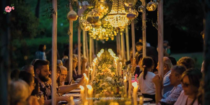 tavolo imperiale nel bosco e ospiti seduti per un matrimonio